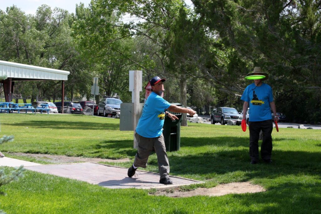 A man in blue shirt holding a frisbee.